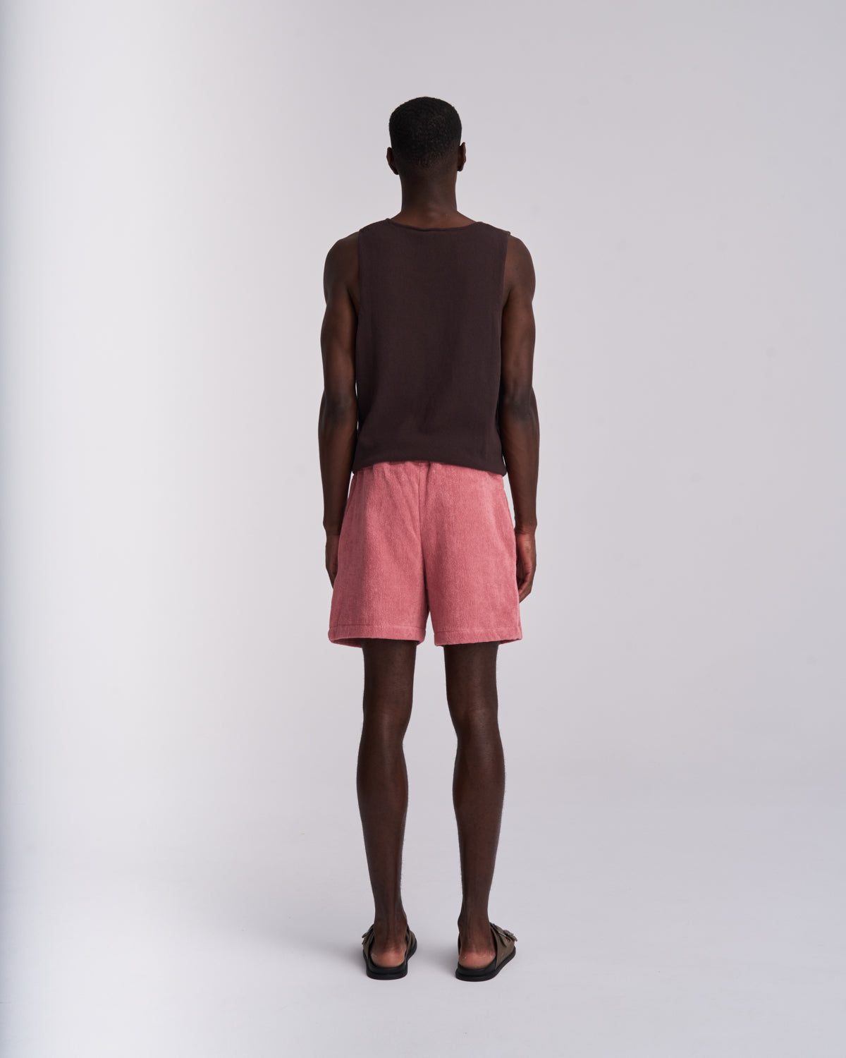 Man wearing Dusty Rose organic cotton terry shorts with elasticated waist, back view on a plain background