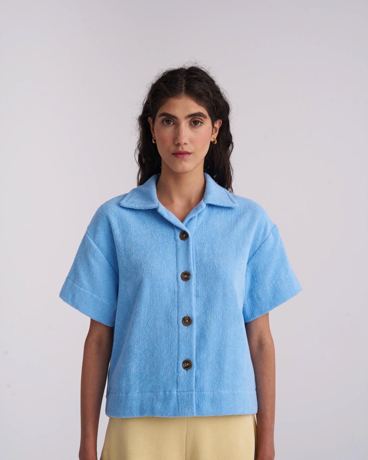 Woman wearing a Coastal Blue organic cotton terry camp-collar shirt, front view