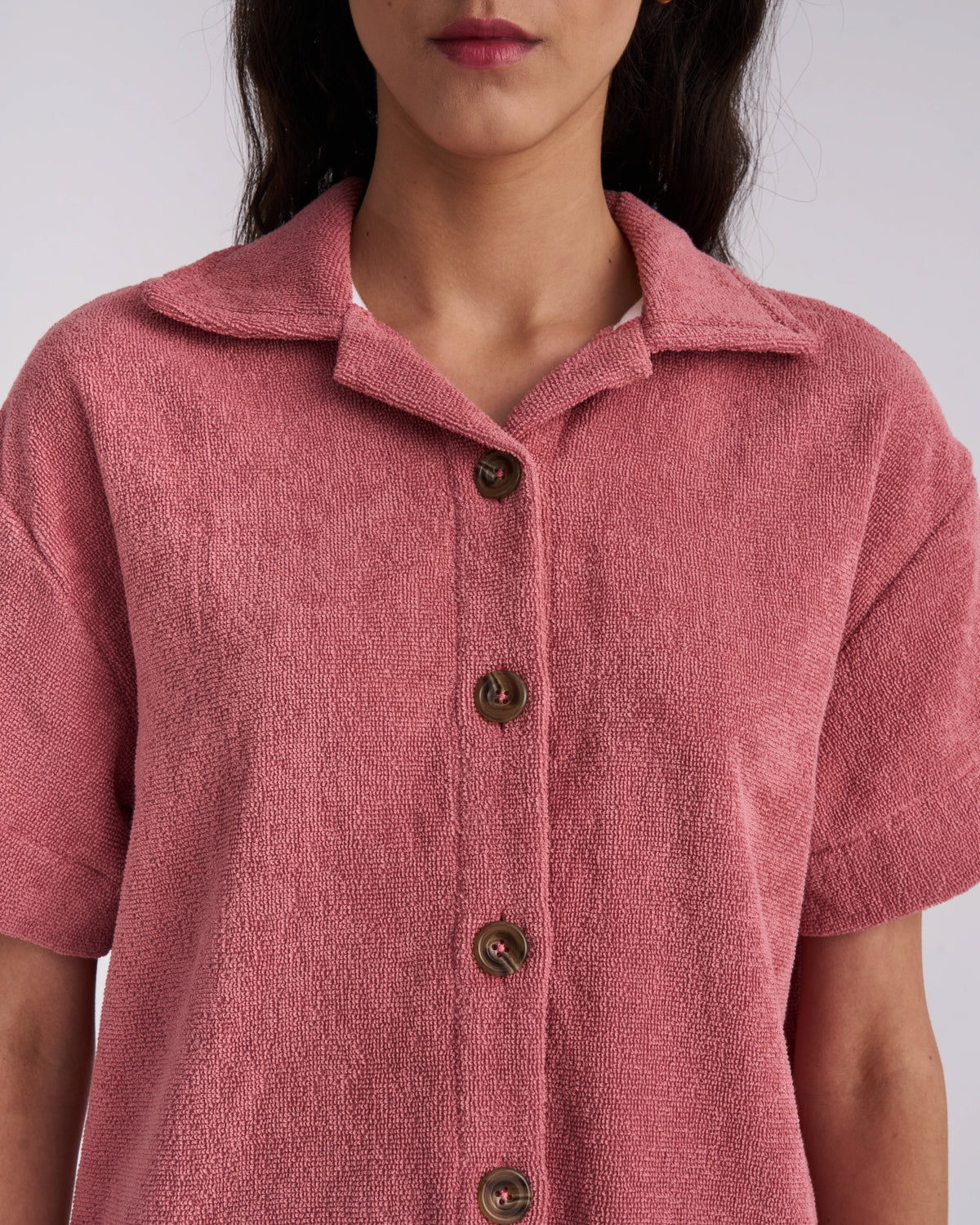 Close-up of the collar and tortoiseshell buttons on a Dusty Rose women's terry camp-collar shirt