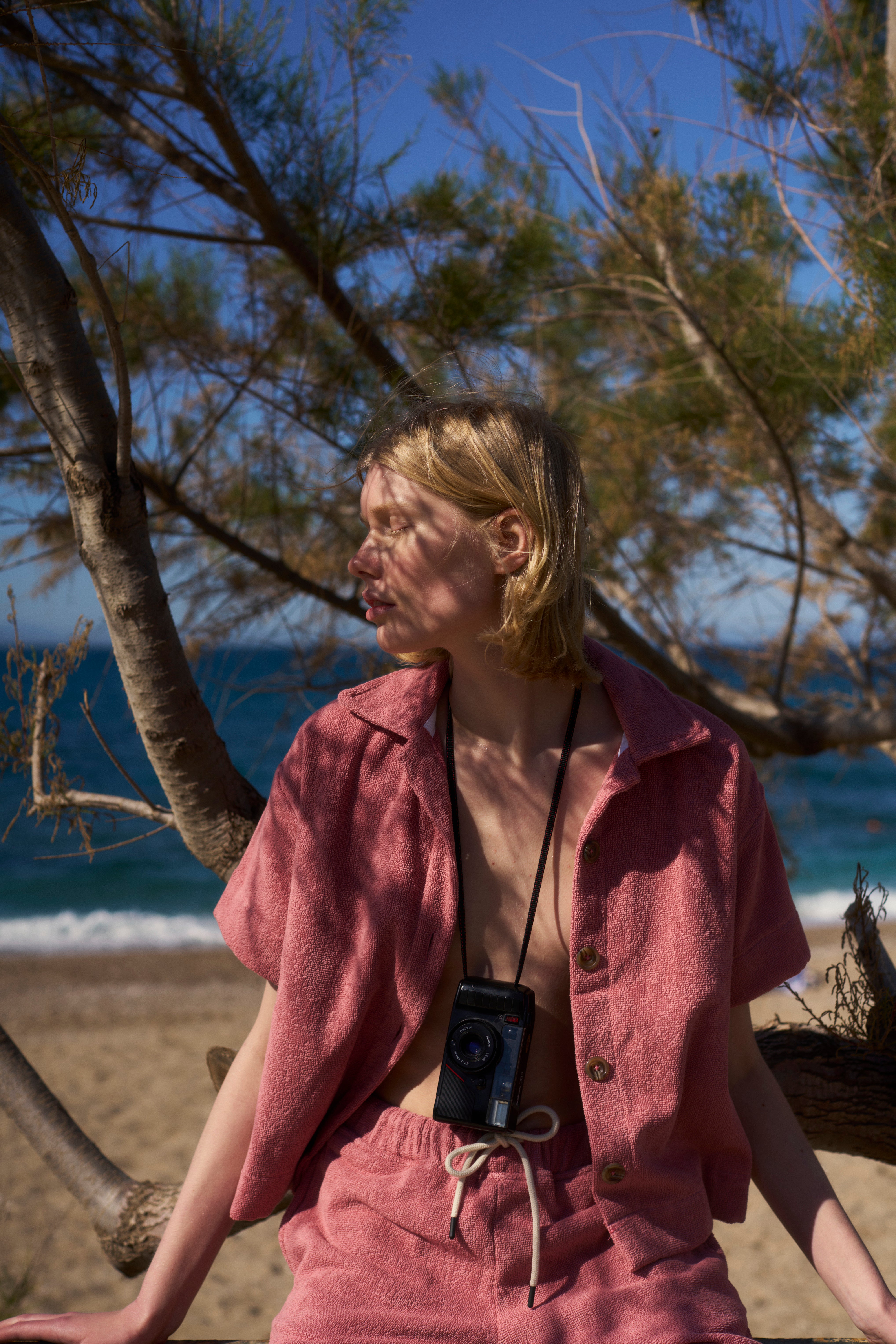 Woman in a Dusty Rose organic cotton terry shirt and shorts by the sea