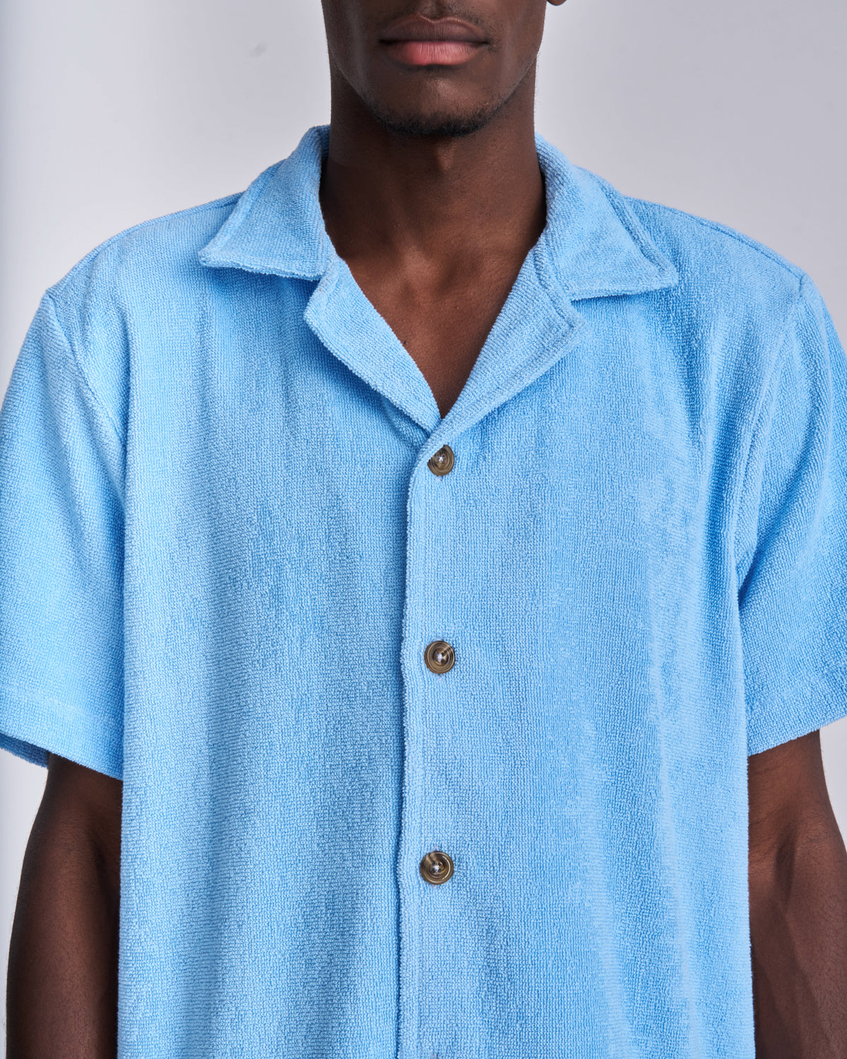 Close-up of the tortoiseshell buttons on a Coastal Blue terry camp-collar shirt