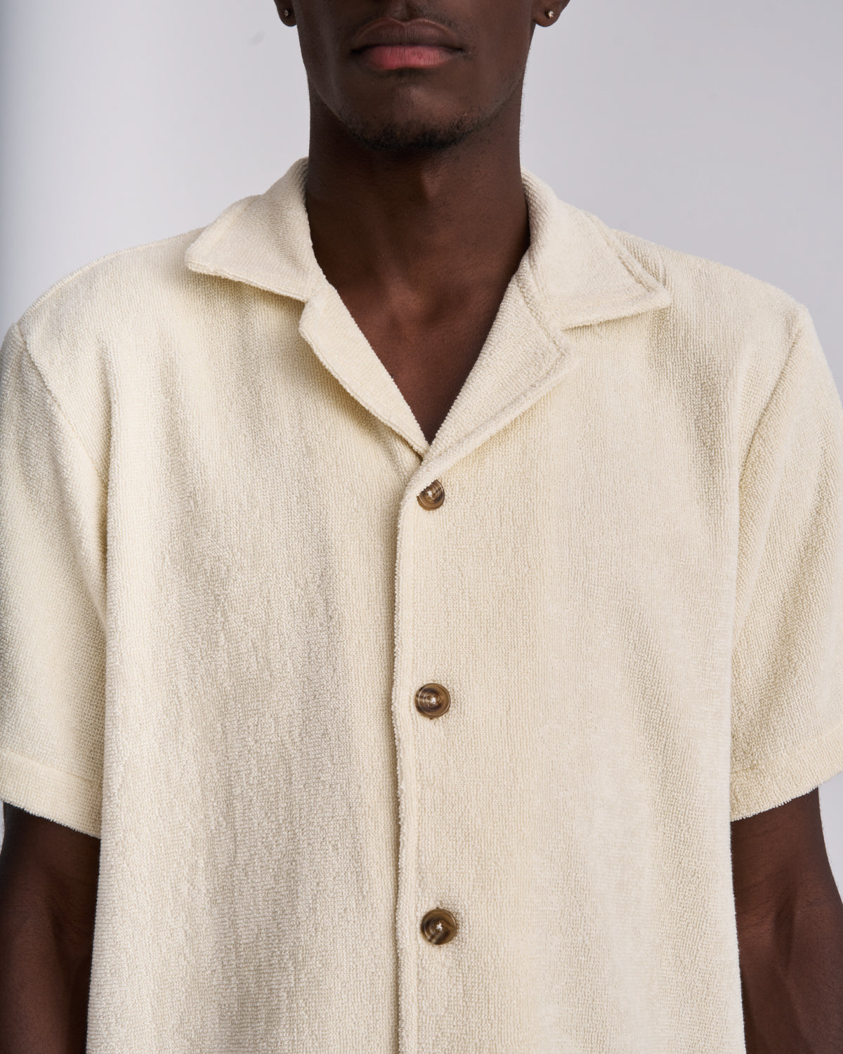 Close-up of the tortoiseshell buttons on an Off-White terry camp-collar shirt