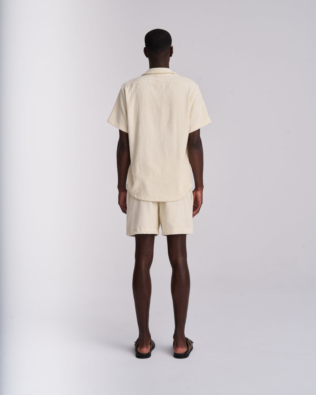 Back view of an Off-White men's organic cotton terry camp-collar shirt with matching Off-White terry shorts