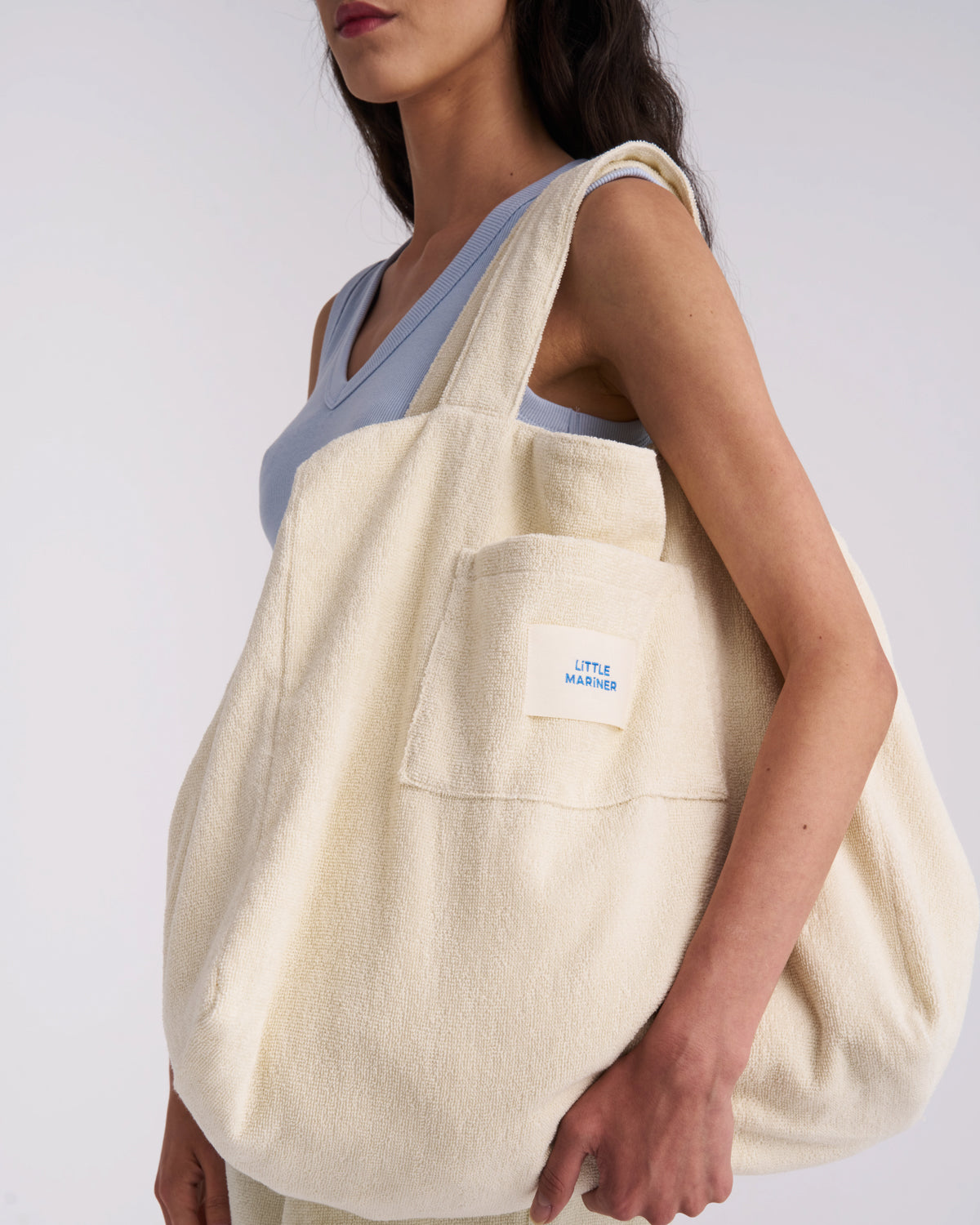 Off-White organic cotton terry tote bag carried on the shoulder, showing its size and front pocket