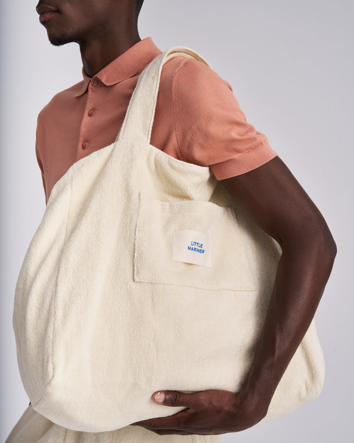 Close-up of an Off-White organic cotton terry tote bag with its front pocket and woven label