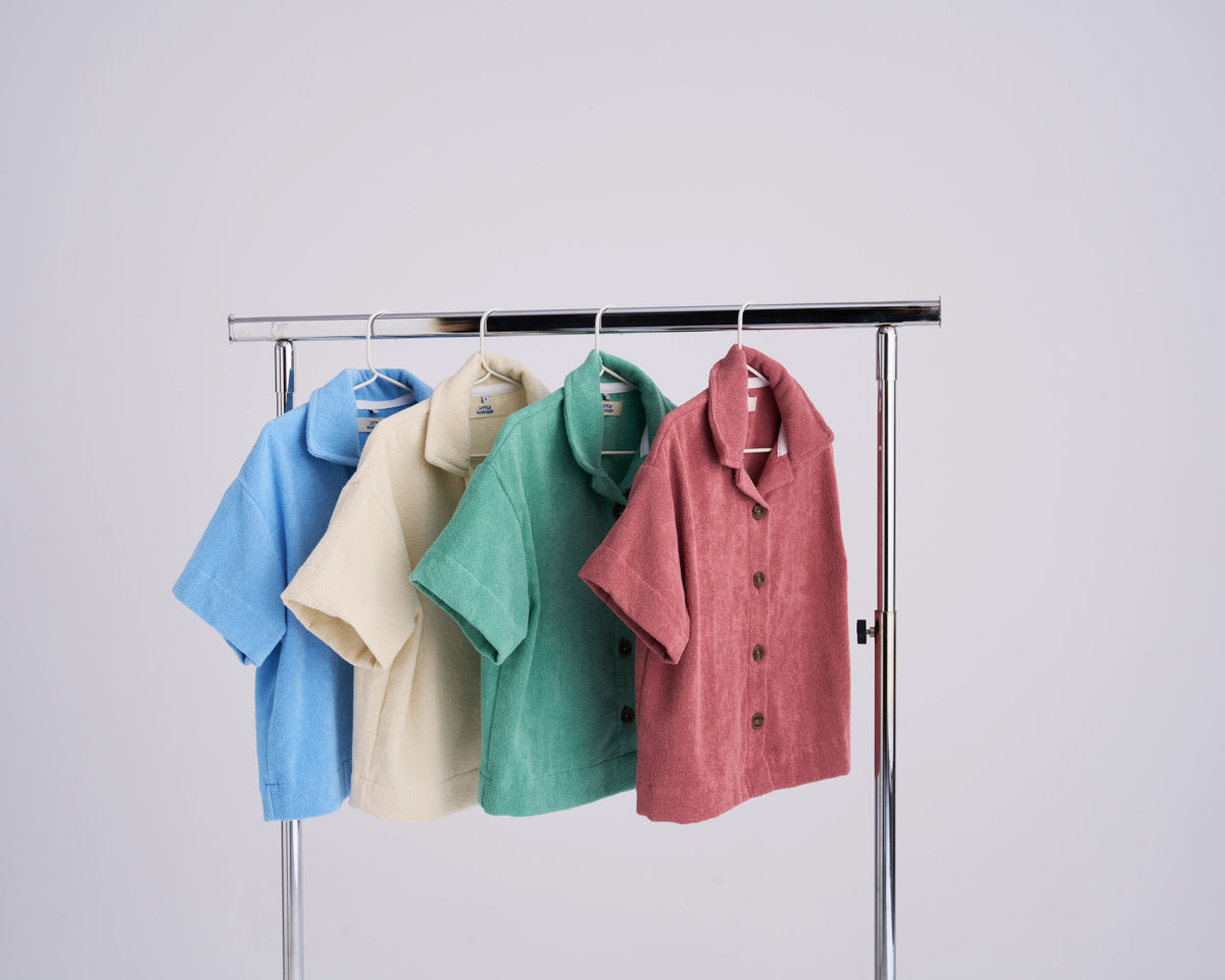 Stack of organic cotton terry shirts in Mediterranean colourways on a white background