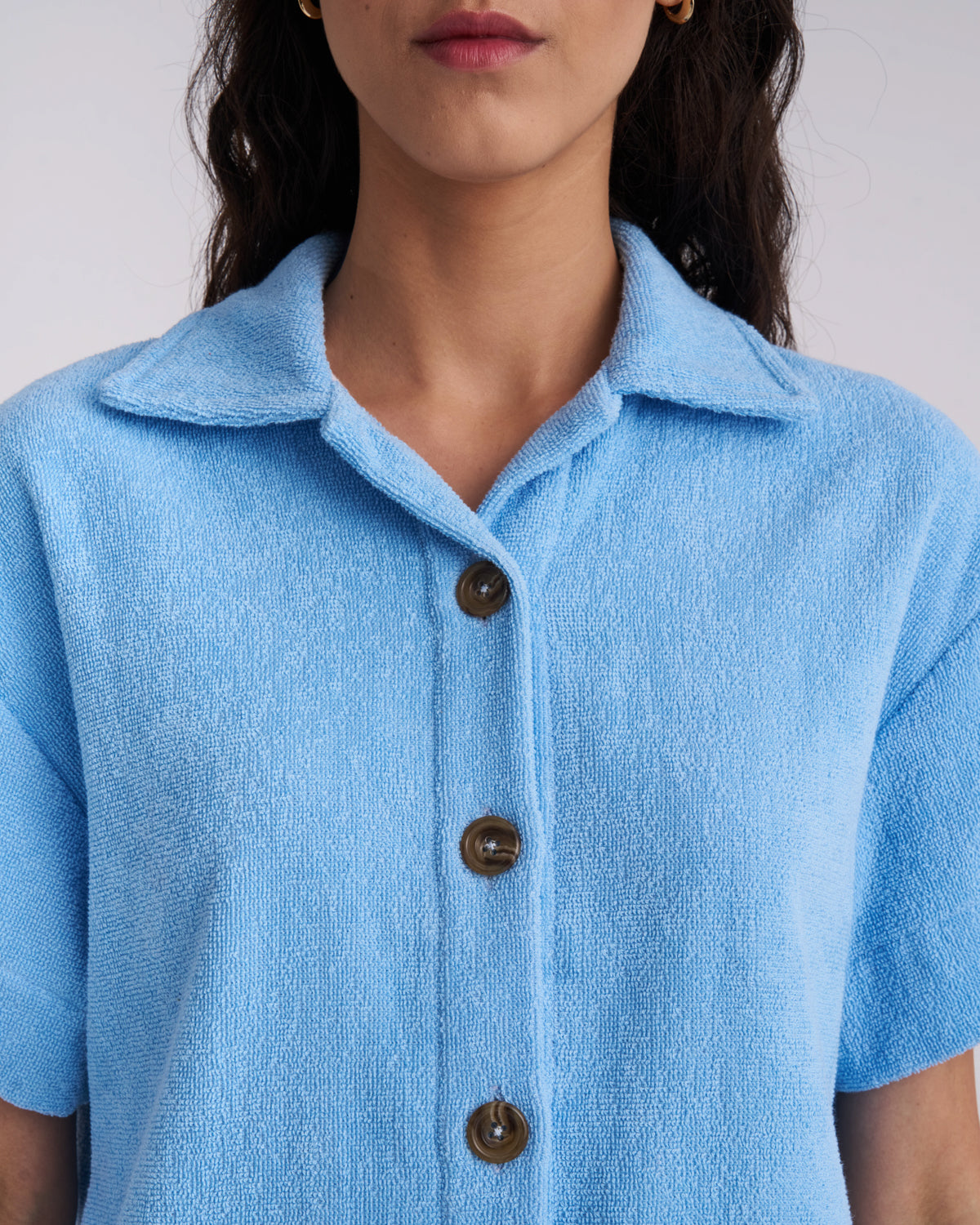 Close-up of the collar and tortoiseshell buttons on a Coastal Blue women's terry camp-collar shirt