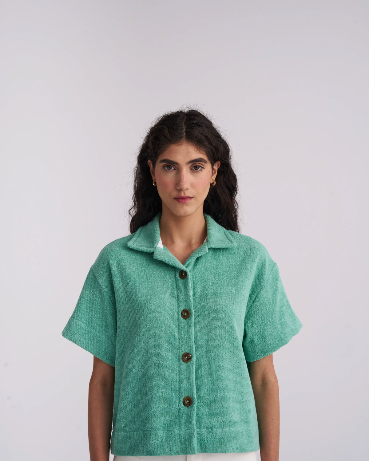 Woman wearing a Sage Green organic cotton terry camp-collar shirt, front view