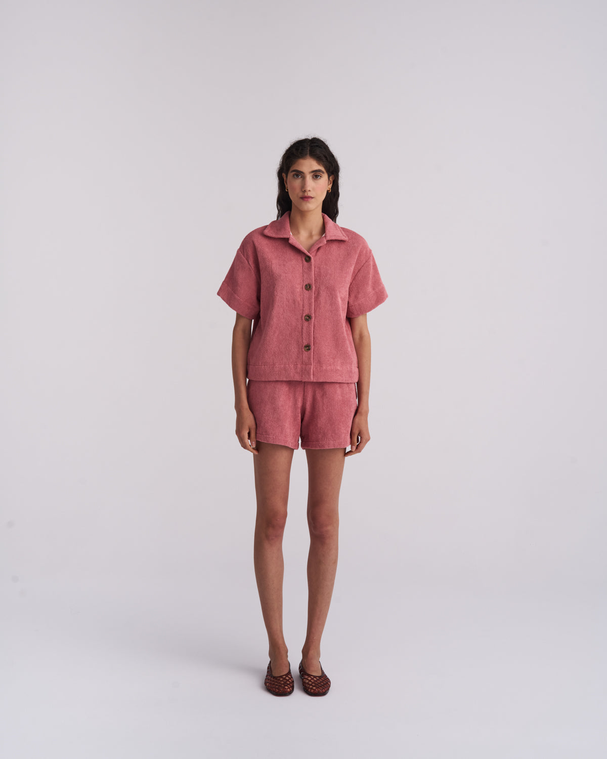 Woman in a Dusty Rose organic cotton terry camp-collar shirt and matching terry shorts, front view