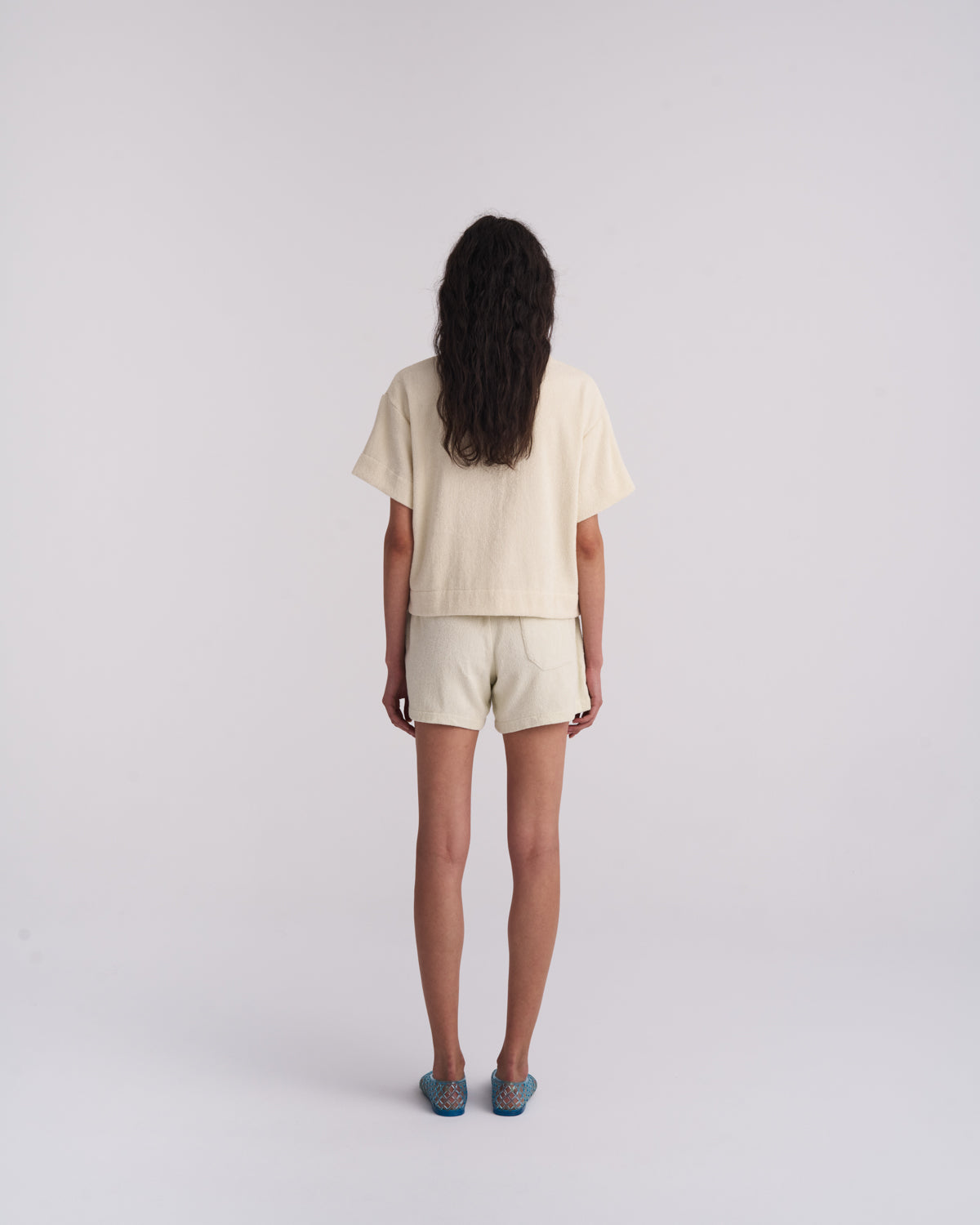 Back view of an Off-White terry camp-collar shirt worn with matching terry shorts