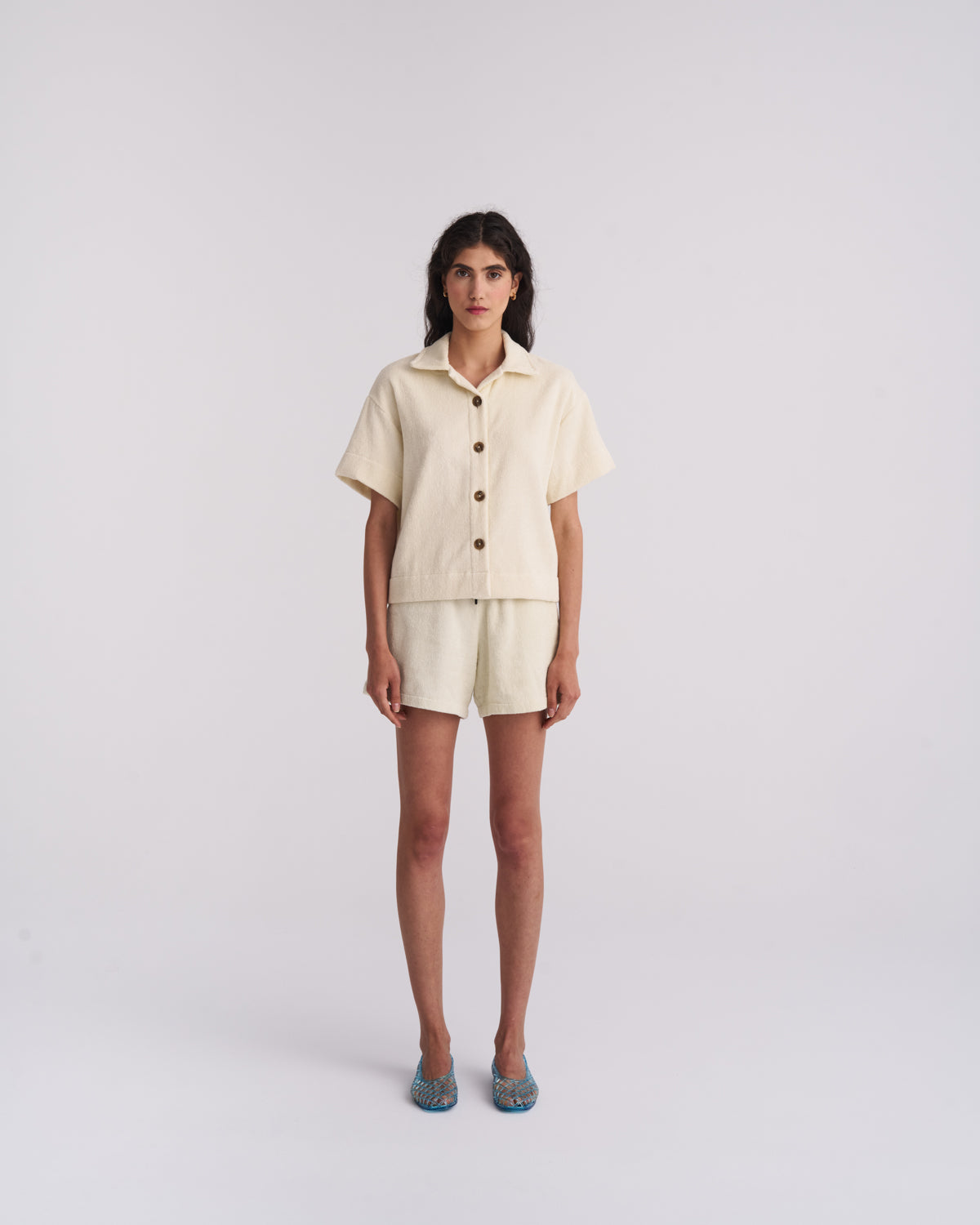 Woman in an Off-White organic cotton terry camp-collar shirt and matching terry shorts, front view